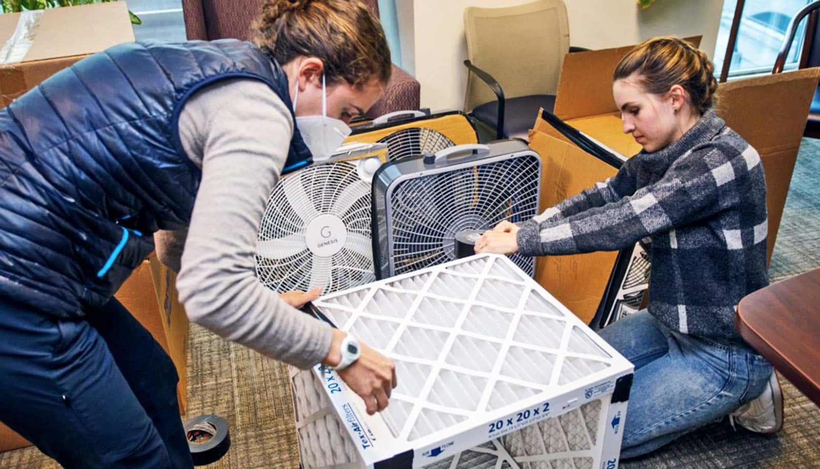 two people assemble filter box