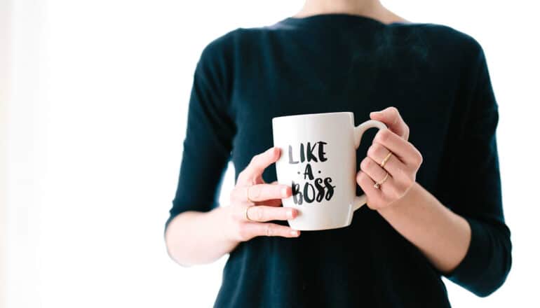 midsection of white person holding "like a boss" mug