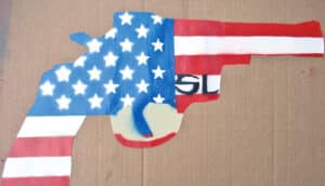 A gun outline filled in with the United States flag's stars and stripes.