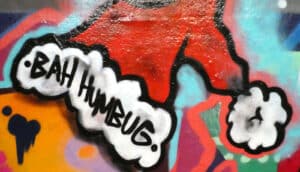 Graffiti of a red Santa hat with the words "Bah humbug" written on the white fuzzy lining.