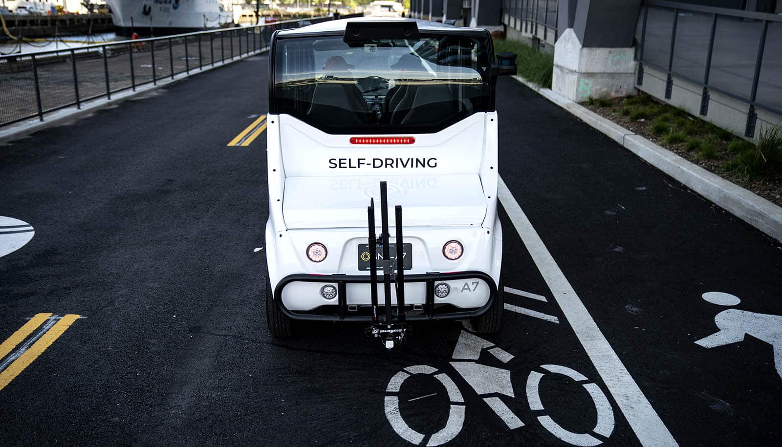 self-driving bus on street with symbols for bike lane and pedestrian walkway