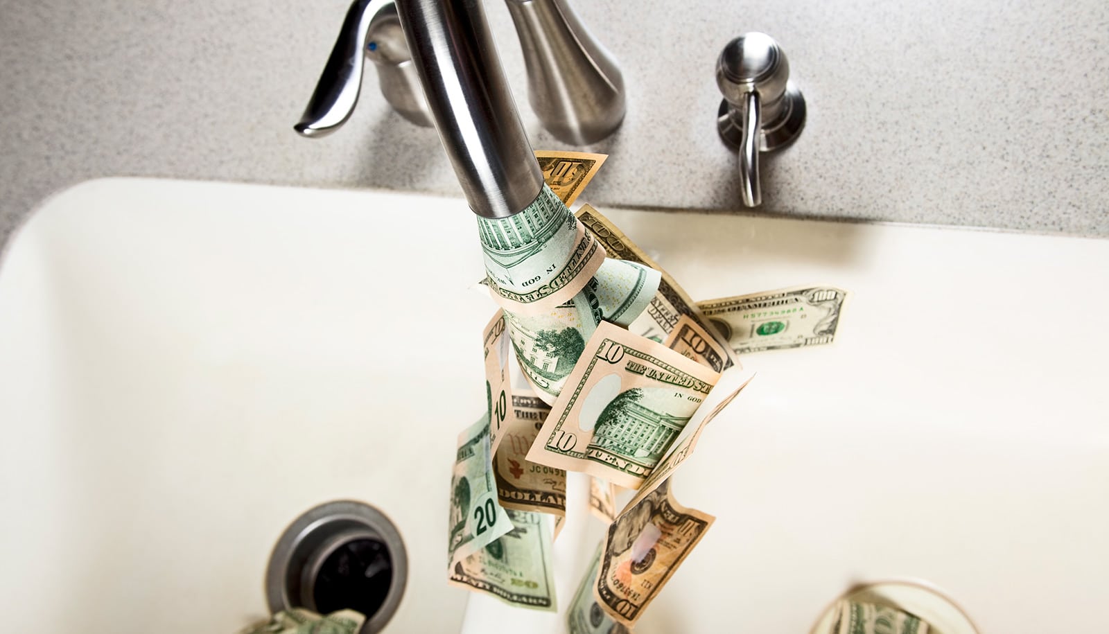 Paper money comes out of a kitchen faucet.
