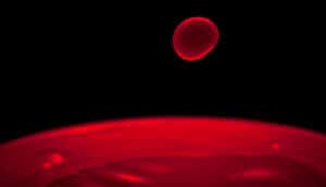 A red drop of liquid against a black background.