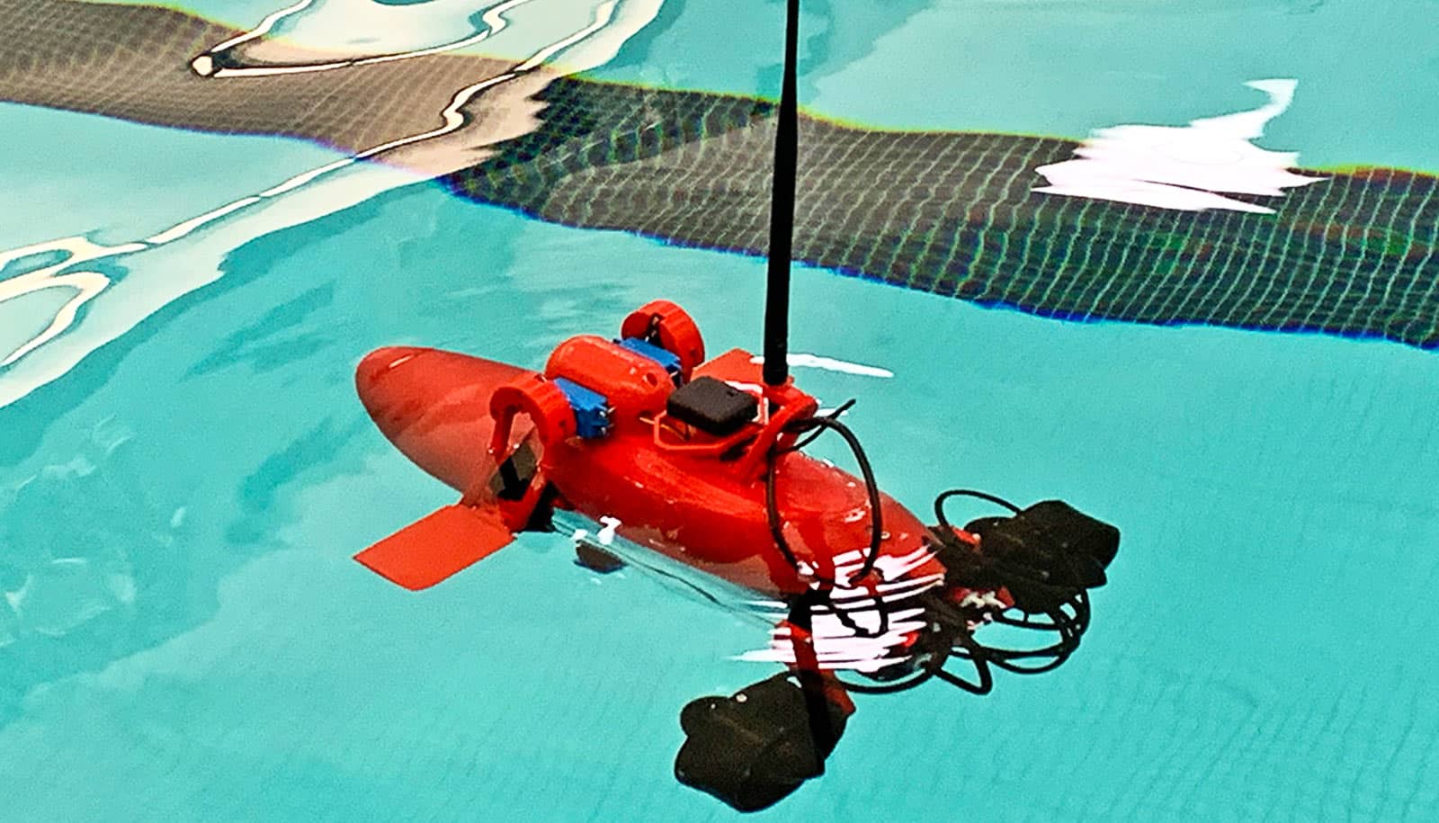 The red semi-submersible swims near the surface of a swimming pool.