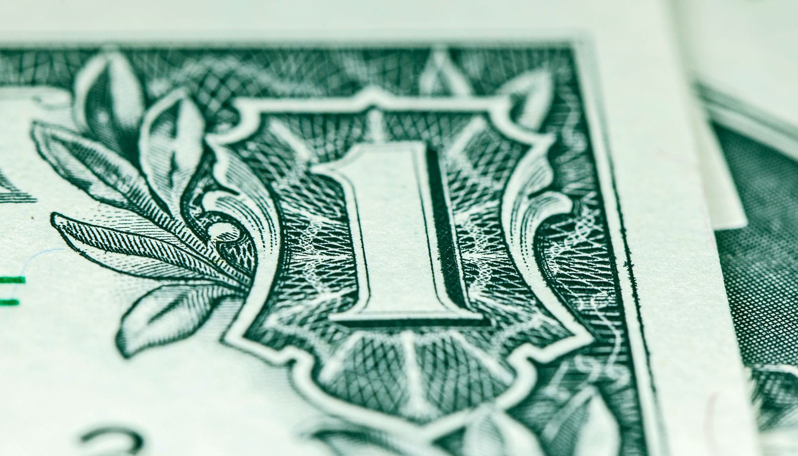 A super close-up of the number one on a one dollar bill.