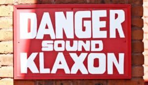 red sign says "danger sound klaxon"