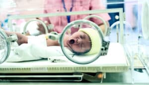 A premature baby in a hospital bassinet.