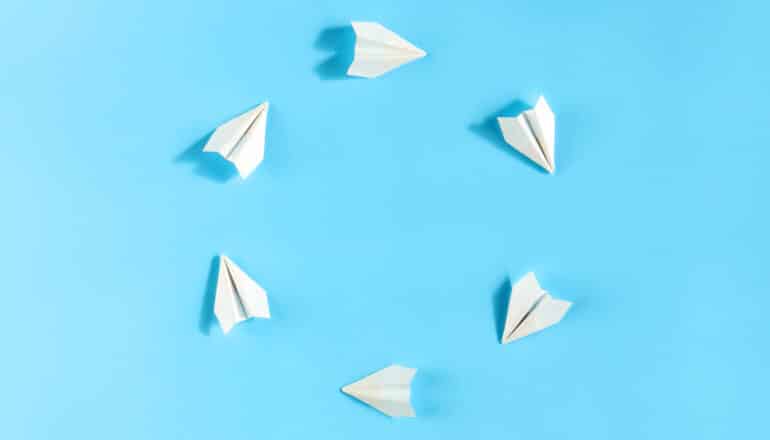 white paper planes in a circle on blue