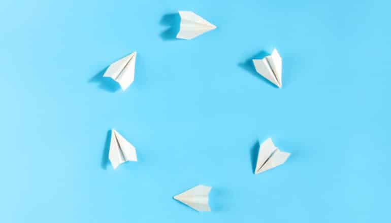 white paper planes in a circle on blue