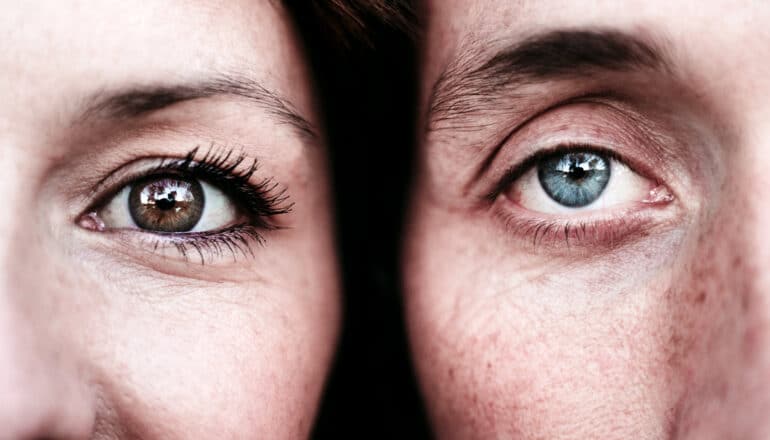 A woman and man next to each other with the close-up showing one eye each.
