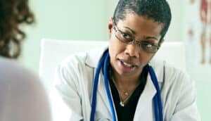 A doctor speaks with a patient in her office.