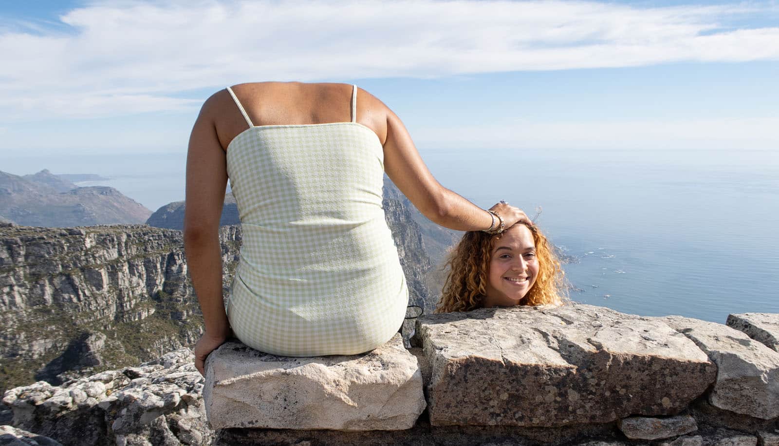 trick pose suggests person sits on ledge holding head beside them
