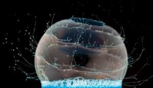 bubble in blue liquid pops, sending out little tendrils