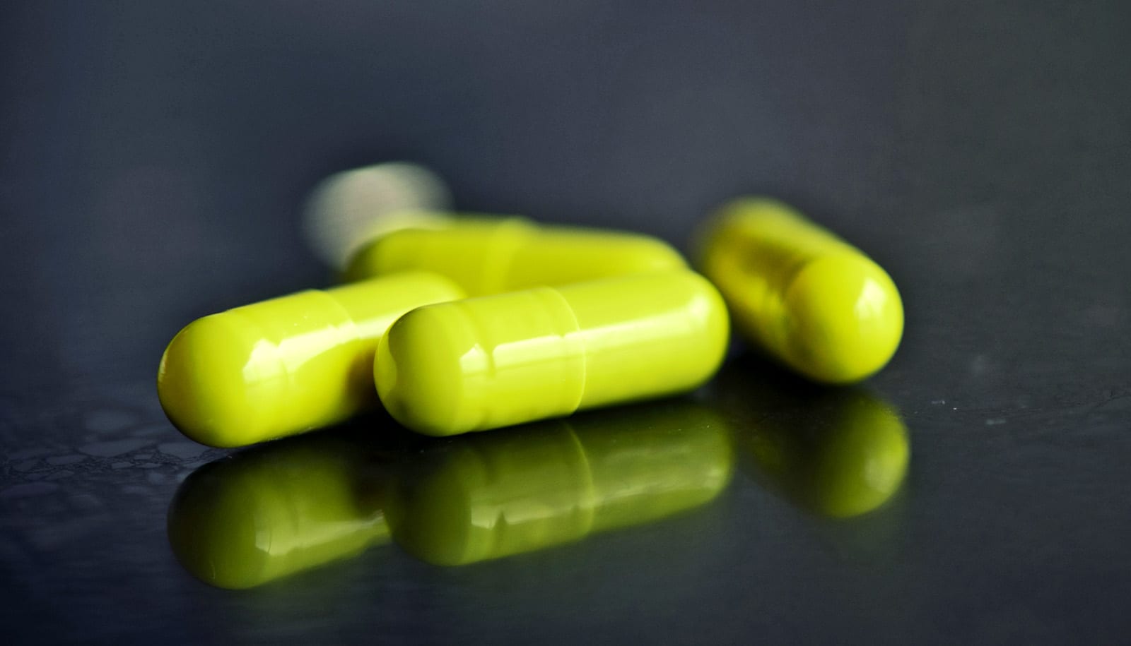 neon green pills on black surface