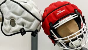 white and red padded covers, one on a dummy's football helmet