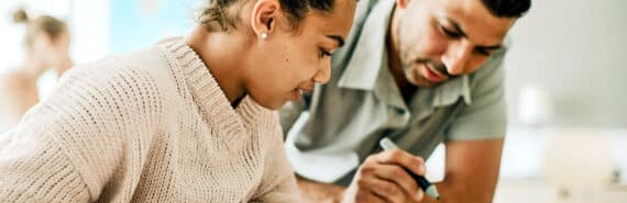 A teacher and student look over an assignment in the classroom.