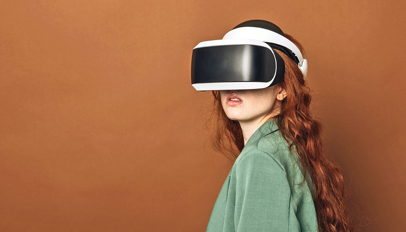 A woman wearing a virtual reality headset looks towards the camera.