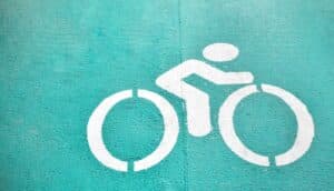 A green bike path has a white biking symbol showing a person on a bike.