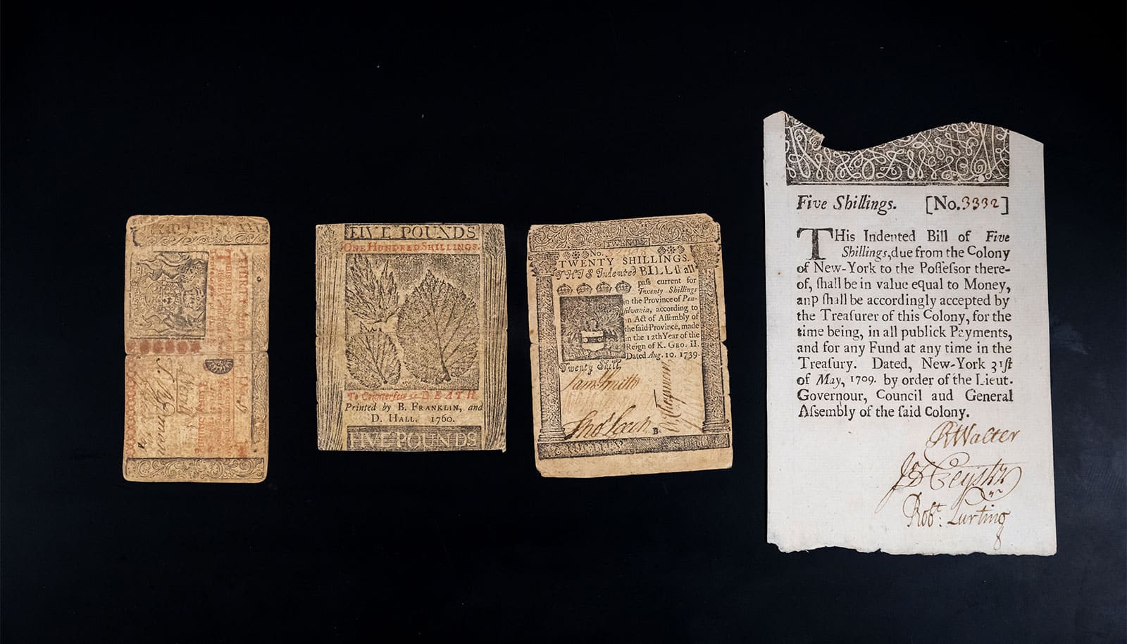 Ben Franklin's bills on a black surface.