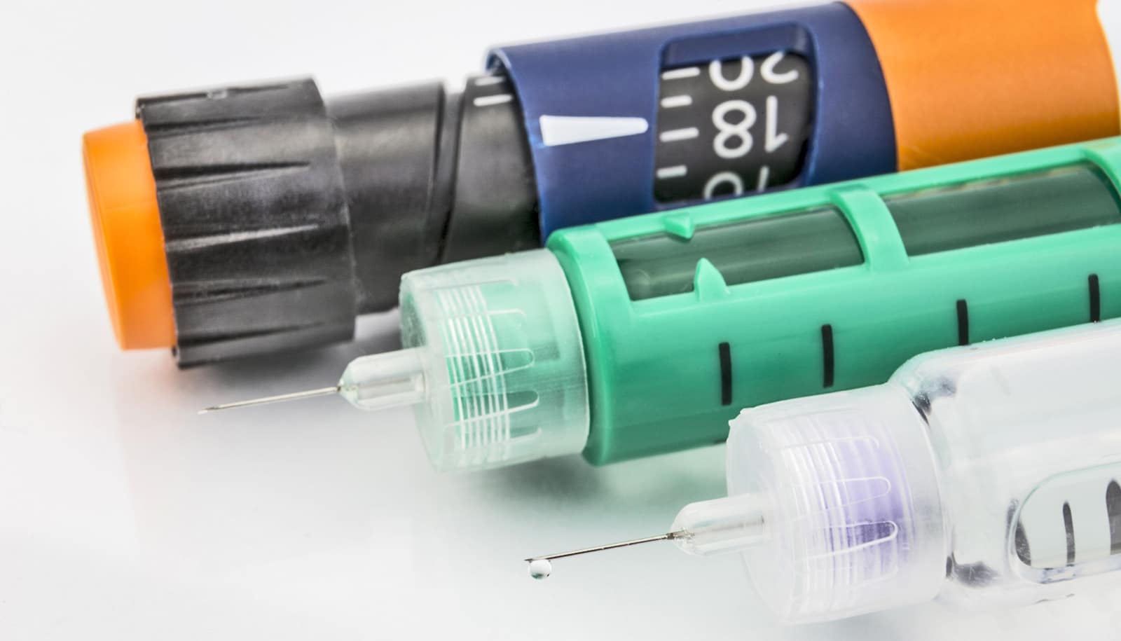 three insulin pens on white