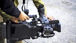 hands hold movie camera close to the ground