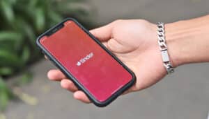 hand holds phone with Tinder on screen