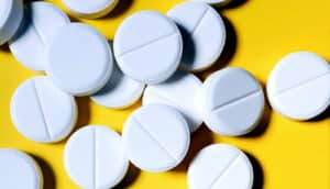 Aspirin on a yellow background.