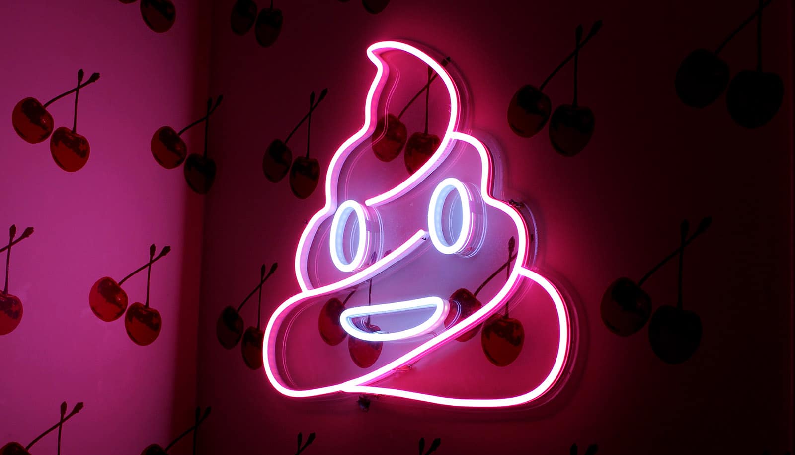neon poop emoji on wall