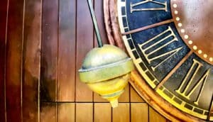 A clock's pendulum swings back and forth.