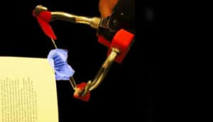The robot gripper turns a single page of a book.