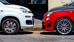 Two cars face each other while parked on a street.