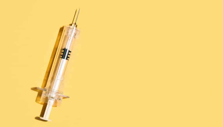 syringe on yellow background