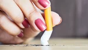 A woman stubs out a cigarette.