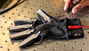 A researcher works on the glove, which has electronics embedded in the fingers.