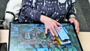 A woman uses Brushlens over a touch screen.