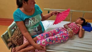 adult fans child on hospital bed