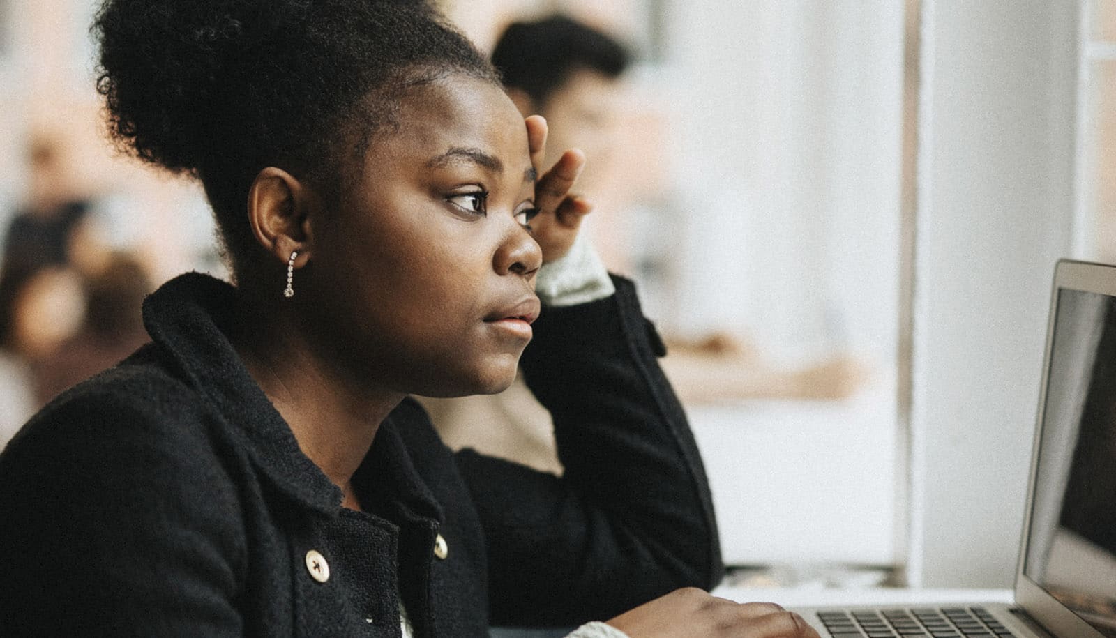serious Black college student looks at laptop