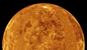 Venus glows orange against a dark background.
