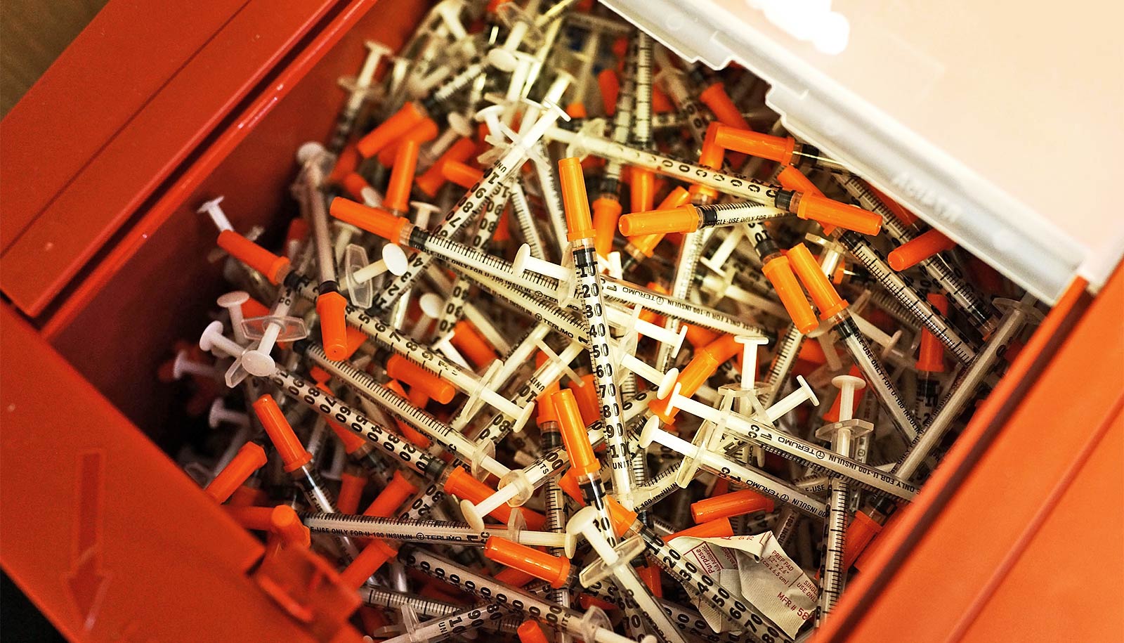 A tub of syringes with orange caps at an overdose prevention center.