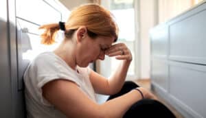 stressed out, sad person sits on floor