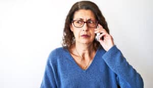 A woman on the phone looks concerned.