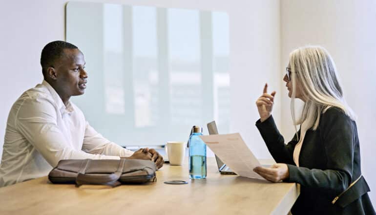 Black man and white woman at table for job interview