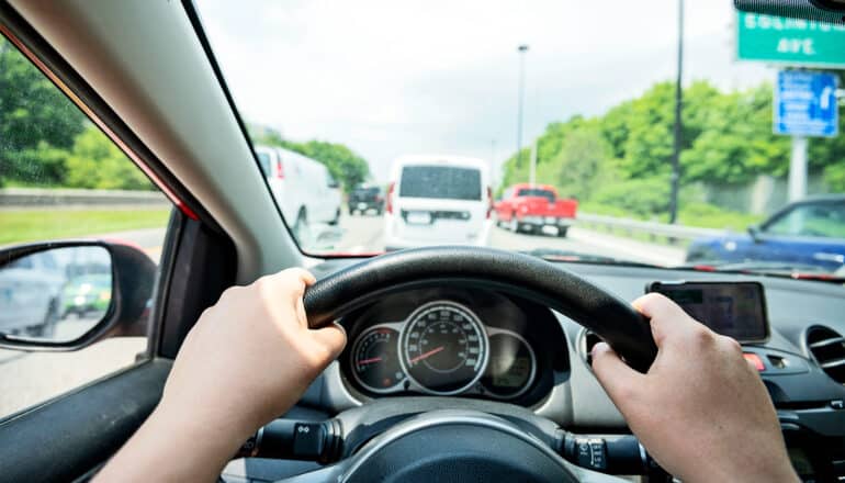 A first-person view of someone driving at rush hour.