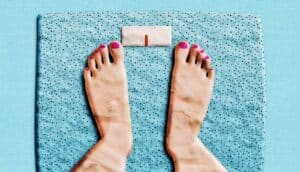 A clay representation of a person's feet on a scale.