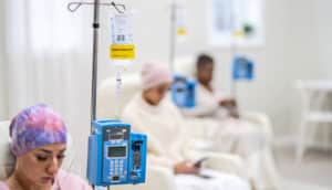 Women sit while receiving chemotherapy treatments at a cancer clinic.