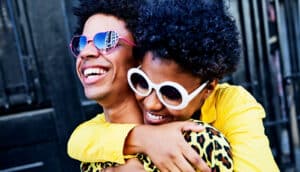 A young couple walking and laughing together while holding each other.