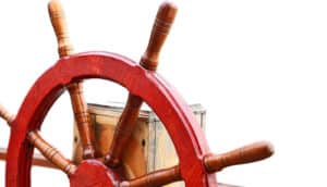 A ship's steering wheel against a white background.