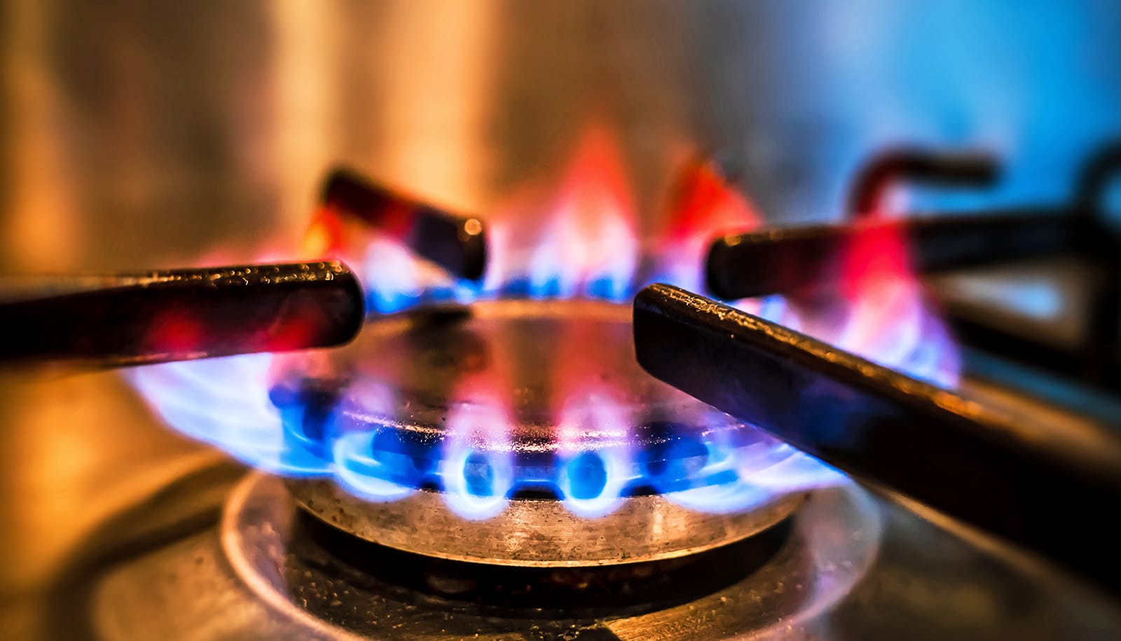 A gas stove with flames coming out of it.