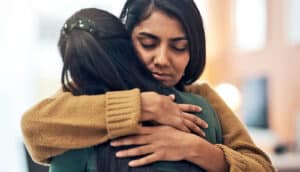 Two friends hug each other.