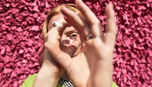 A woman looks through her hands as if she's looking through an invisible telescope.